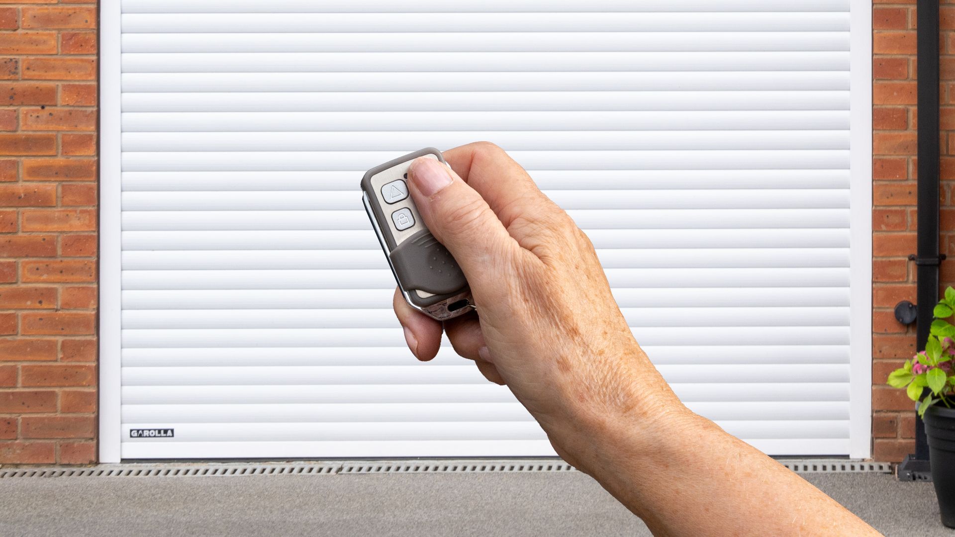 Homeowner opening Garolla roller garage door with remote