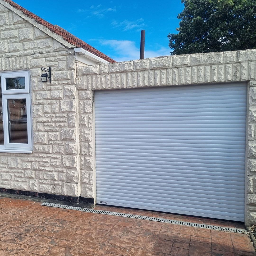 Garolla Transform 55mm white electric roller garage door on painted white house