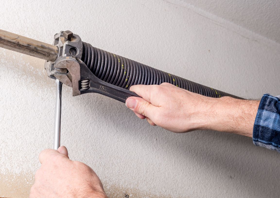 Garage door torsion string being repaired