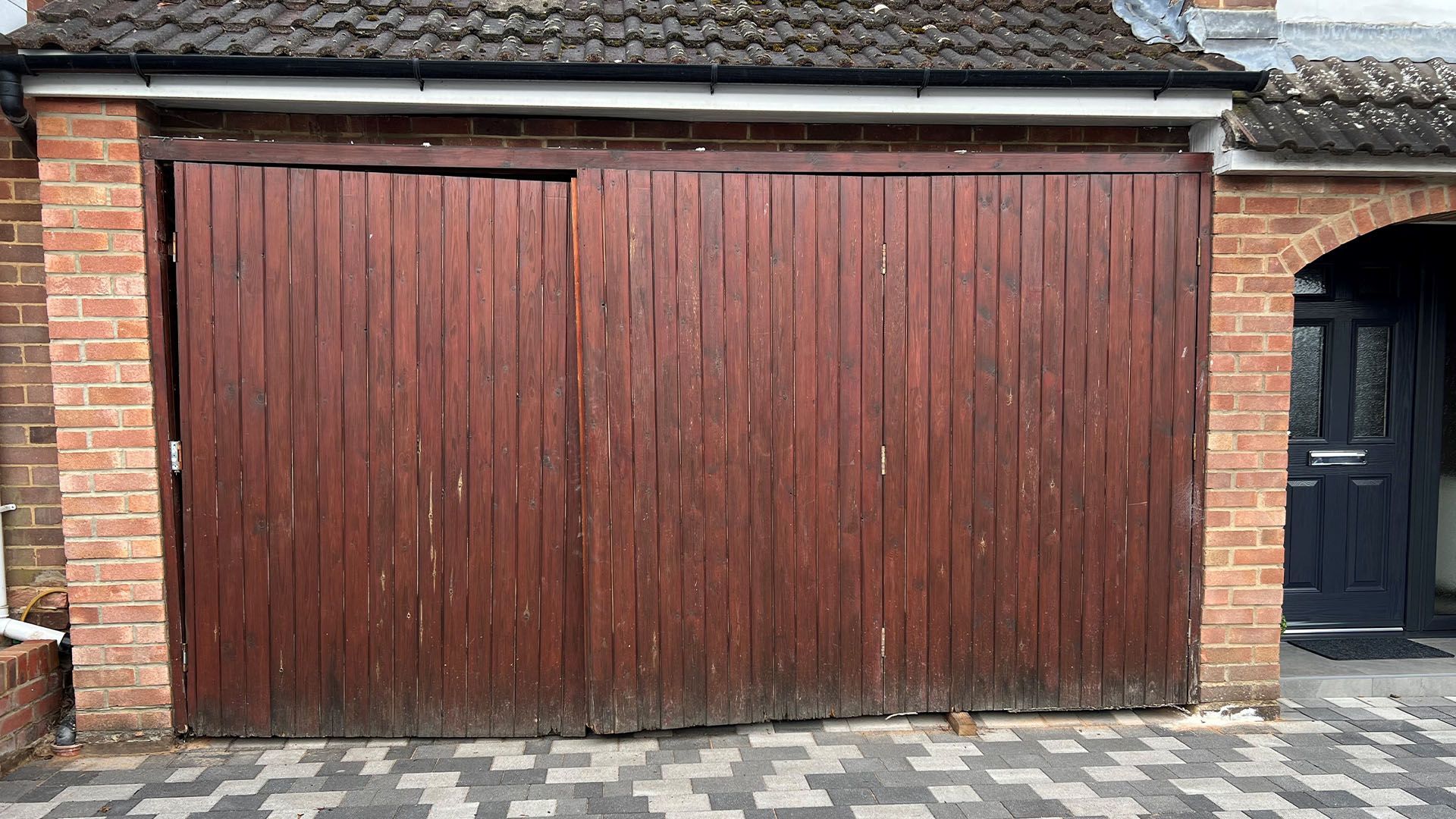 Broken wooden garage doors in need of replacement