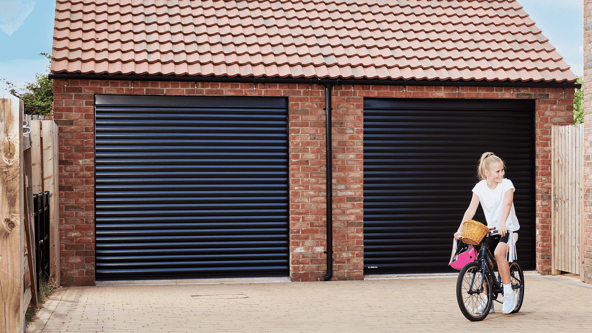 Child riding bike in front of Garolla double garage