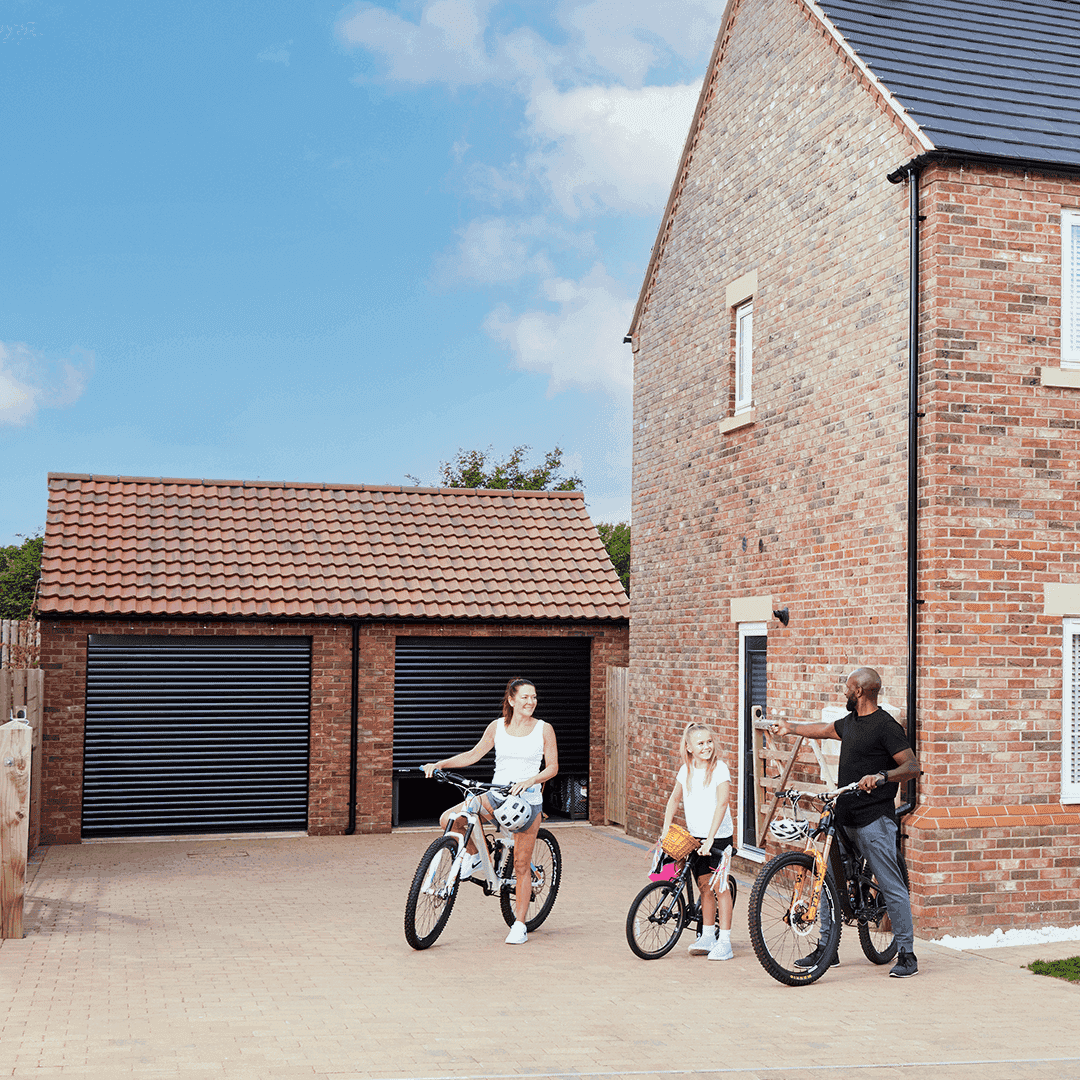 Family riding bikes in front of Garolla Transform Pro double garage doors