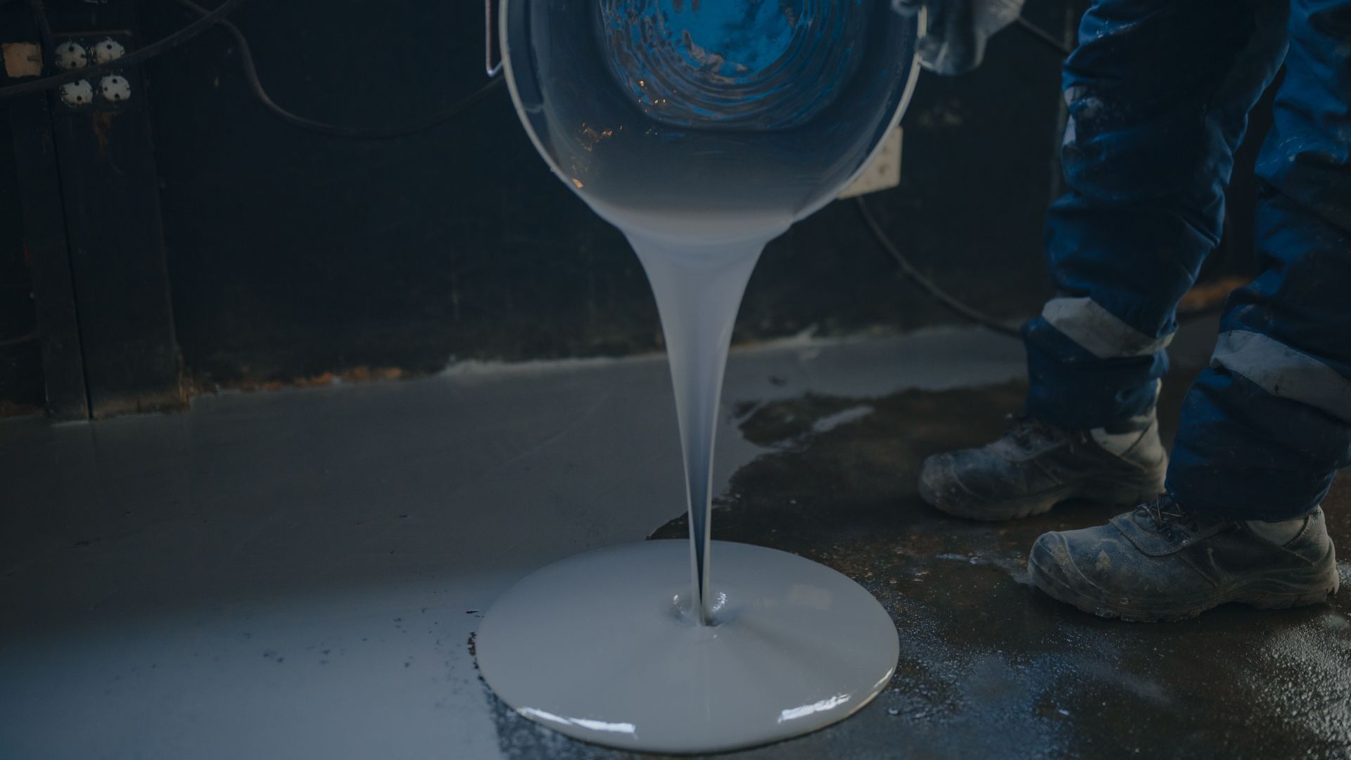 Garage floor paint being poured on to floor; new garage conversion