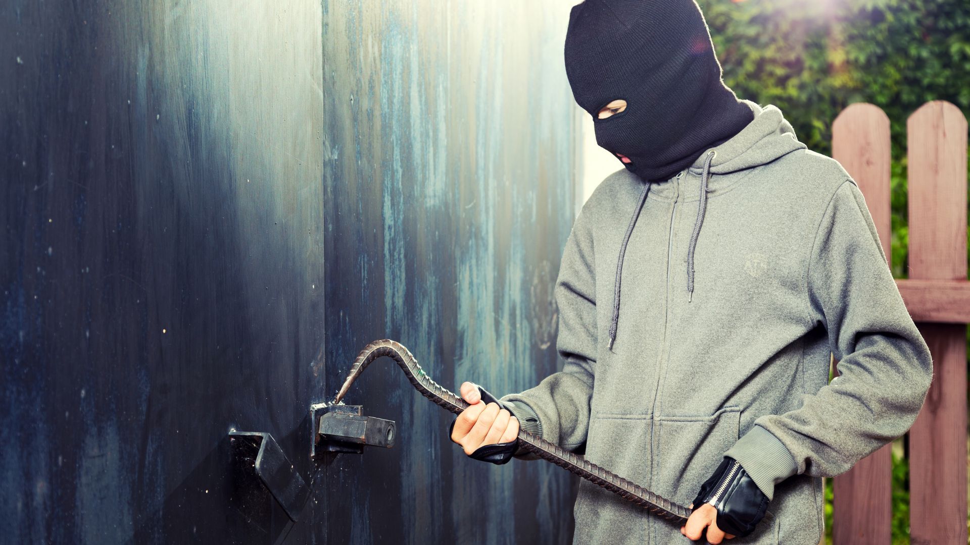 Burglar breaking into old garage door