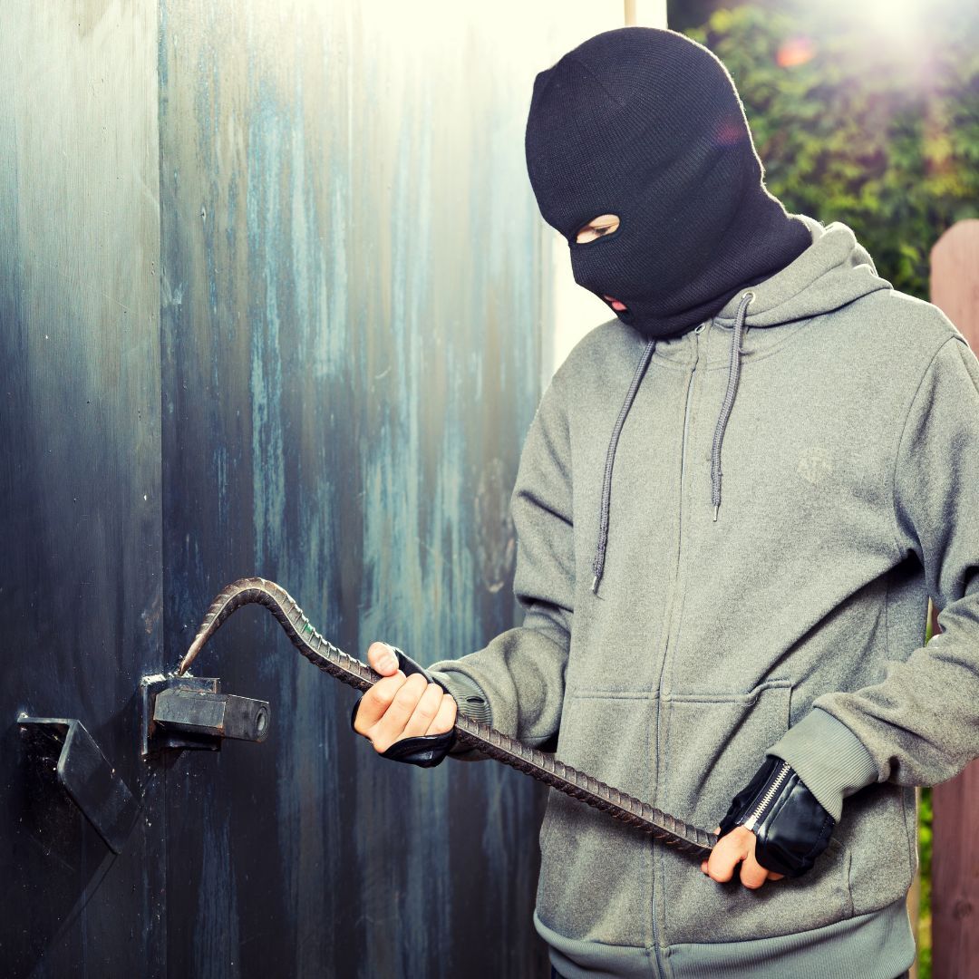 Burglar breaking into old garage door