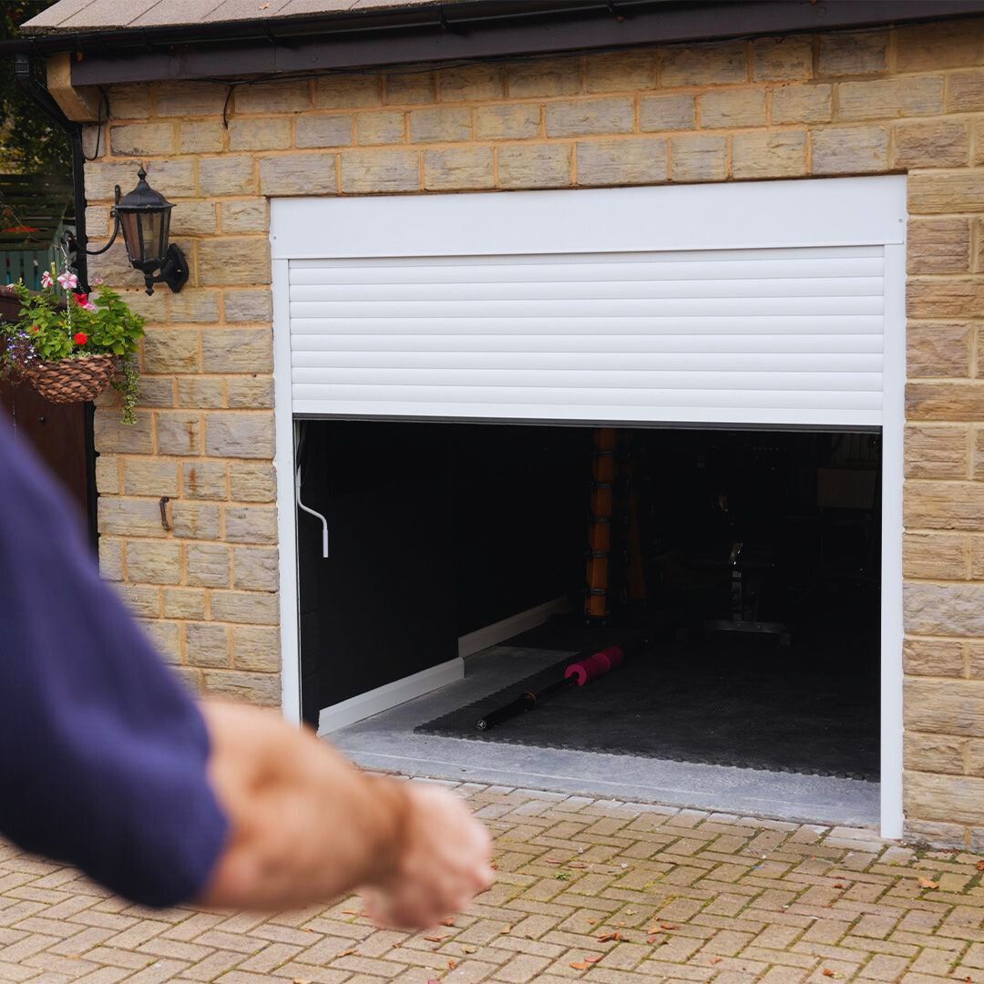 Man opening white Garolla Transform Pro electric roller garage door