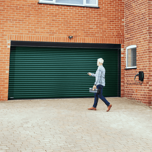 Man using fob to open green Garolla Titan Shield electric roller door